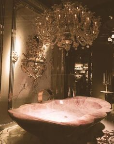 a fancy bathtub in the middle of a room with chandelier above it