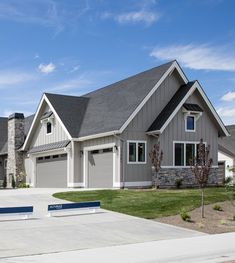 a large gray house with two garages on each side
