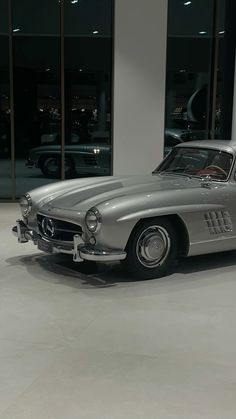 an old mercedes sports car parked in front of a building