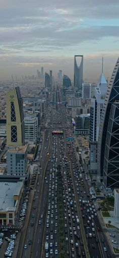 an aerial view of a city with lots of traffic and tall buildings in the background