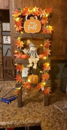 a wooden shelf with pumpkins and fall leaves on it