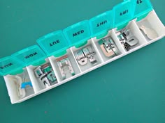 the inside of a sewing machine in its storage case on a green surface with scissors and thread