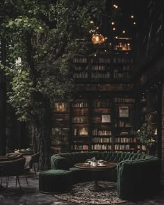a living room filled with green couches and bookshelves