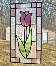 a stained glass window with a pink tulip