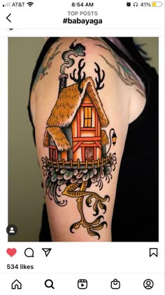 a woman's arm with a house tattoo on it