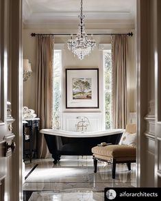 a bathroom with a claw foot tub and chandelier hanging from it's ceiling
