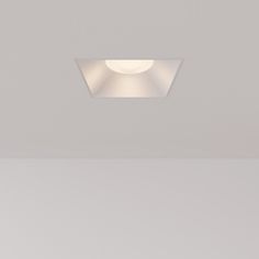 an empty room with a white ceiling light