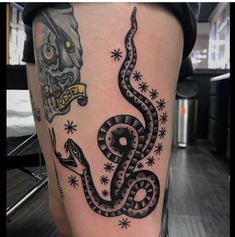a black and white tattoo on the leg of a person with a skull in the background