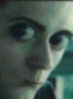 a close up of a person talking on a cell phone and looking at the camera