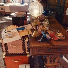an antique desk with many pieces of luggage on it and a lamp in the middle