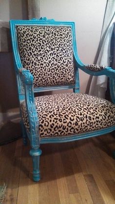 a leopard print chair sitting on top of a hard wood floor