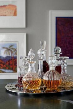 three glass decanters are sitting on a tray