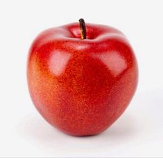 an apple that is red and shiny with some brown tips on it's side