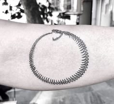 a black and white photo of a person's arm with a tattoo on it