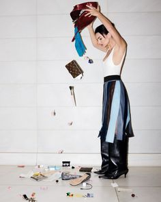 a man standing on top of a floor holding a red purse over his head with confetti all around him