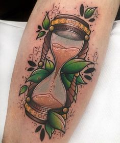 a tattoo with an hourglass and leaves on it