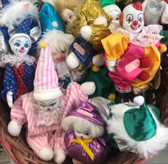 a basket filled with lots of different colored stuffed animals and clown hats on top of each other