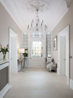 a white room with a chandelier hanging from the ceiling