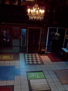 an empty room with tiled floors and chandelier in the background at night time