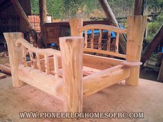 a wooden bed frame sitting on top of a pile of wood