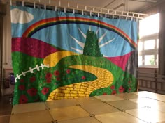 a colorful shower curtain with a football field and flowers on the outside, in front of a window