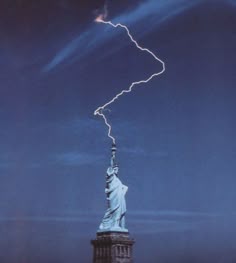 a lightning bolt is seen over the statue of liberty