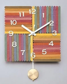 a clock made out of strips of colored paper with numbers on the face and hands