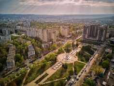 an aerial view of a city with lots of tall buildings and trees in the foreground