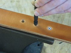 a person is working on something with a small screwdriver and some metal studs