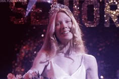 a woman wearing a tiara standing next to a man