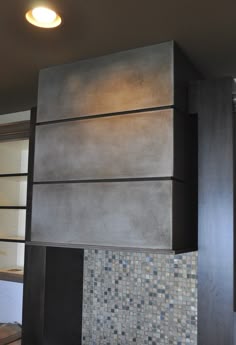 a stove top oven sitting inside of a kitchen next to a wall with tile on it