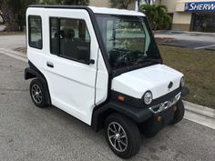 a white and black golf cart parked on the street