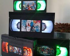 there are three vhss stacked on top of each other with green light coming from them