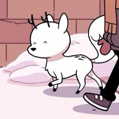 a person walking with a dog in their hand on a snowy surface next to a brick wall