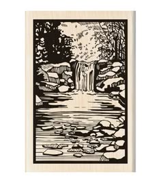 a wood mounted rubber stamp with a waterfall in the middle and trees on either side