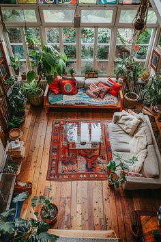 a living room filled with furniture and lots of plants on top of it's windows