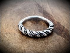 A Viking style twisted wire ring, delicately forged by hand in sterling silver and polished to a high shine. The band is 4mm wide at the front, tapering to 2mm at the back. Made to order in any size, please check the size chart if you are unsure. Twisted Polished Jewelry As A Gift, Modern Stackable Toe Rings, Twisted Stackable Promise Rings, Hand Forged Open Ring With A Modern Twist, Classic Hand Forged Stackable Rings For Promise, Hand Forged Ring With A Modern Twist, Silver Stackable Rings With A Modern Twist, Adjustable Modern Twist Stackable Toe Rings, Modern Twist Spiral Stackable Rings As Gift