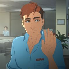 a man in an office holding his hand up