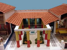 an aerial view of a house with red and yellow roof tiles on the front porch