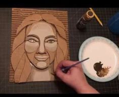 someone is drawing a woman's face on a piece of paper with a paintbrush