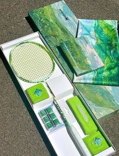 the contents of a green and white box are laid out on the ground next to each other