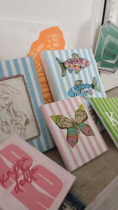 several colorful paintings are on the floor next to each other in front of a door