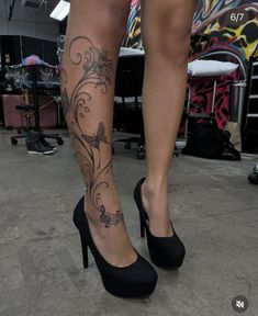 a woman's legs with tattoos and high heels