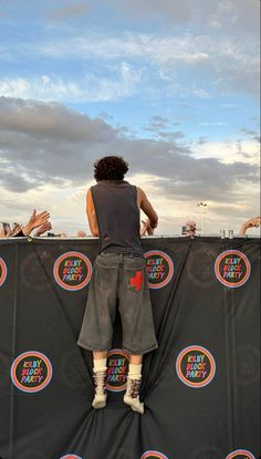 a man standing on top of a stage with his hands in the air while holding onto a frisbee