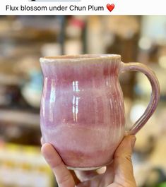 a person holding a pink mug in their hand
