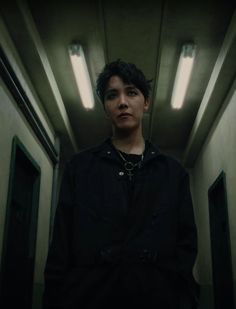 a young man standing in an empty hallway