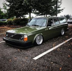 a green station wagon parked in a parking lot