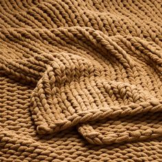 a knitted blanket laying on top of a bed