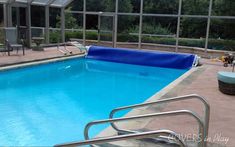 an empty swimming pool with chairs around it