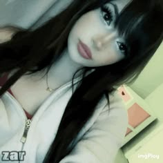 a woman with long black hair wearing a white shirt